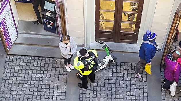 <p>Strážník Městské policie hlavního města Prahy uděluje pokutu za nedovolenou jízdu na elektrické koloběžce  po chodníku v Praze 1 na Starém Městě. Snímek jsem pořídil na nádvoří Richtrova domu. Jednalo se o nedovolenou jízdu po chodníku. </p>