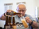 Penzista z domova pro seniory nalévá do sklenice leák Opa vlastní výroby. (24....