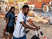 Aboriginská rodina prochází kolem malby na zdi v australském Alice Springs....