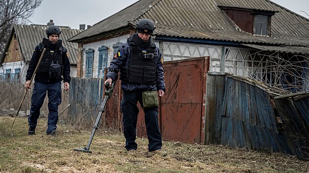 Ženista Státní pohotovostní služby kontroluje zaminovanou oblast a hledá nevybuchlé granáty v Charkovské oblasti. (21. března 2023)