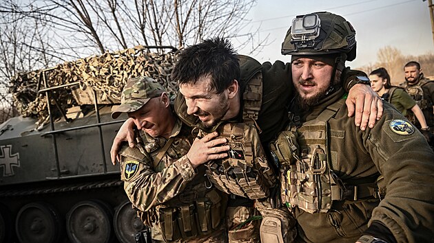 Ukrajinští vojáci odnášejí raněného spolubojovníka z fronty u Bachmutu. (23. března 2023)