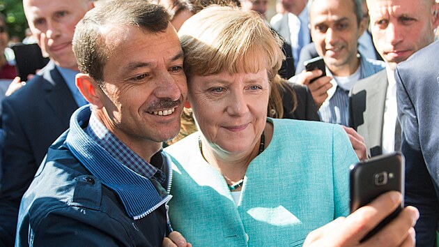 adatel o azyl si poizuje selfie s nmeckou kanclkou Angelou Merkelovou po jej nvtv poboky Spolkovho adu pro migraci a uprchlky a prvnho registranho centra pro adatele o azyl v Berln. (10. z 2015)