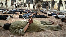 Ameri�tí vojáci kontrolují irácké v�zn� na irácké základn� v Nad�áfu. (21....