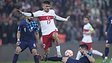 Turecký fotbalista Cengiz Under peskakuje Josipa Sutala z Chorvatska.