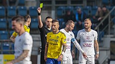 Zlínský fotbalista Martin Fillo dostává žlutou kartu v zápase se Slováckem....