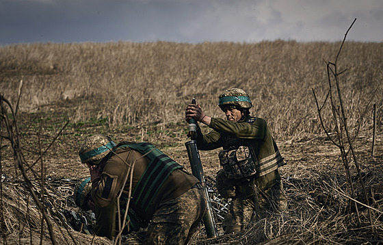 Ukrajintí vojáci 28. brigády pálí z minometu na ruské pozice na frontové linii...
