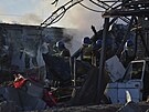 lenové ukrajinské pohotovostní sluby odklízejí trosky budovy, která byla...