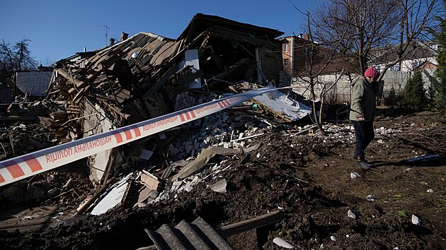 Obyvatelka Charkova prochází kolem budovy zničené ruským raketovým útokem. (31. března 2023)