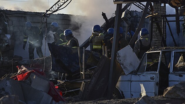 Členové ukrajinské pohotovostní služby odklízejí trosky budovy, která byla zničena v důsledku ruského útoku v Záporožském okrese na Ukrajině. (31. března 2023)