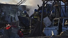 Členové ukrajinské pohotovostní služby odklízejí trosky budovy, která byla...
