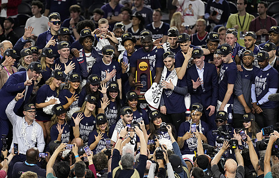 Basketbalisté Connecticutu se svými trenéry a leny týmu kepí po triumfu v...