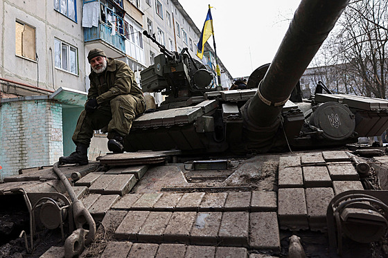Ukrajinský voják sedí na tanku poblí rozbombardovaného Bachmutu. (2. dubna...