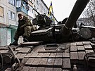 Ukrajinský voják sedí na tanku poblí rozbombardovaného Bachmutu. (2. dubna...