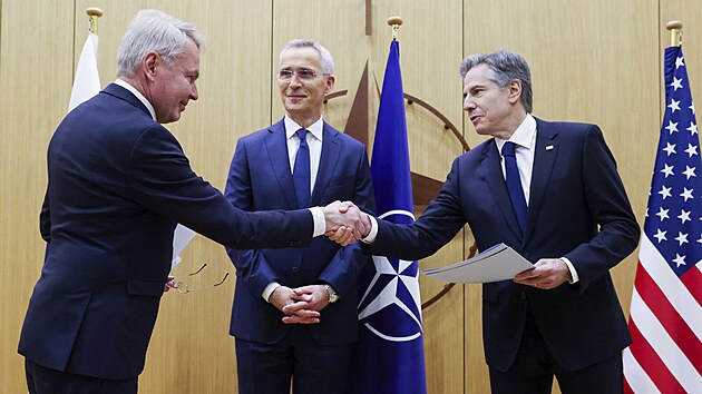 Finsk ministr zahrani Pekka Haavisto (vlevo) pedv pstupov dokumenty svmu americkmu protjku Antony Blinkenovi (vpravo) v centrle NATO v Bruselu. Uprosted generln tajemnk Aliance Jens Stoltenberg. (4. dubna 2023)