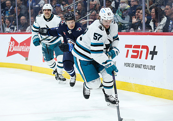 Adam Ra�ka (57) ze San Jose Sharks uniká Vladislavu Namestnikovovi z Winnipeg...