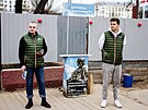 Rutí úedníci stojí u náborového stánku v Moskv, kde zájemcm rozdávají...