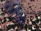 Satelitní snímek ukazuje hoící budovy a vojenskou hlídku severovýchodn od...