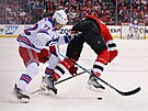Filip Chytil (72) z New York Rangers bojuje o puk v zápase s New Jersey Devils.