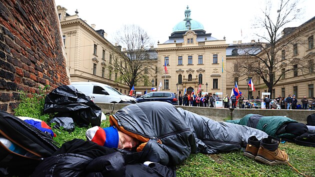 Protivldn demonstranti nocovali ped sdlem vldy ve Strakov akademii v Praze. Pinesli si spac pytle. (17. dubna 2023)
