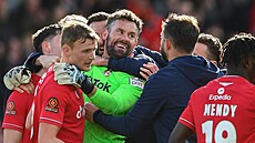 Branká� Ben Foster v oble�ení spoluhrá�� z Wrexhamu. V poslední minut� zápasu s...