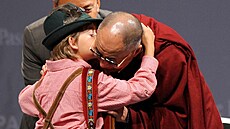 Exilový tibetský duchovní dostal polibek od malého chlapce v tradičním...
