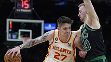 Vít Krejí (27) z Atlanta Hawks se tlaí ke koi Boston Celtics, brání ho Sam...