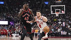 Zach LaVine (8) z Chicago Bulls útoí v zápase s Toronto Raptors, brání ho...