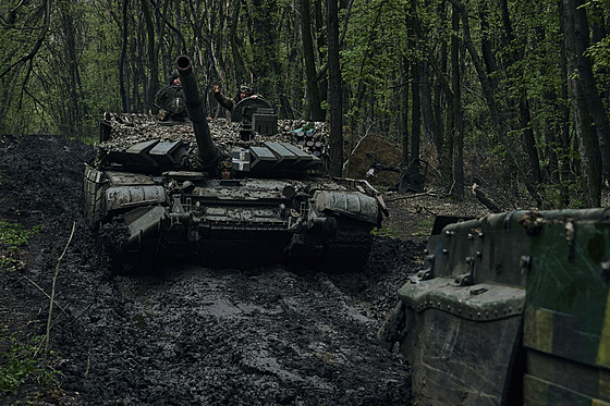 Ukrajintí vojáci mávají na projídjícím tanku na frontové linii u Bachmutu....