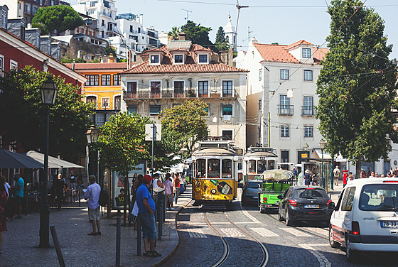 Typická lisabonská tramvaj v obleení aut v jedné z nejstarích tvrtí Alfama....