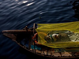 Pevozník spí na loce v Bangladéi (6. bezna 2023)