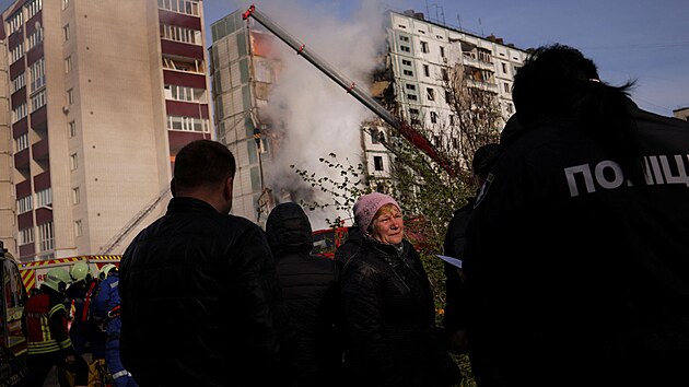 Lid stoj u tce pokozenho obytnho domu zasaenho ruskou raketou ve mst Uman v erkask oblasti na Ukrajin. (28. dubna 2023)