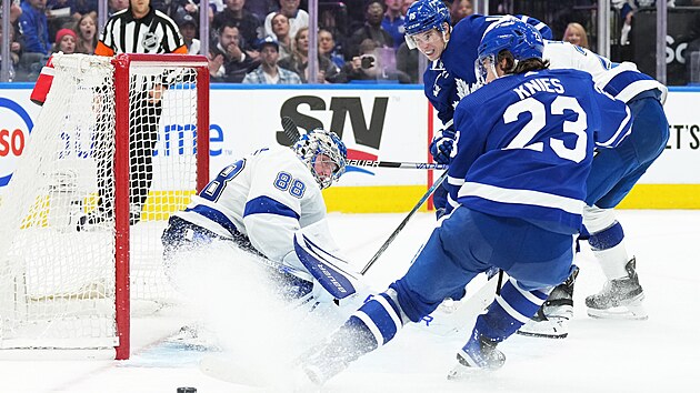 Matthew Knies (vlevo v pop�ed�) z Toronta v �anci p�ed brank��em Andrejem Vasiljevsk�m z t�mu Tampa Bay.