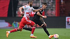 Aissa Laidouni z Unionu Berlín stíhá Piera Hincapieho z Bayeru Leverkusen.