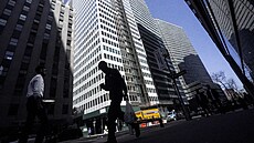 Silueta chodce na pozadí budovy ve finanní tvrti newyorského Manhattanu (11....