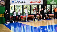 Nymburtí basketbalisté se radují na lavice v hale USK Praha.