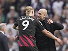 Trenér Manchesteru City Pep Guardiola objímá Erlinga Haalanda po zápase s...
