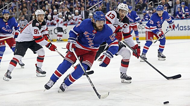 Ryan Lindgren z New York Rangers (v popředí) se žene za pukem v šestém zápase prvního kola play off NHL proti New Jersey.