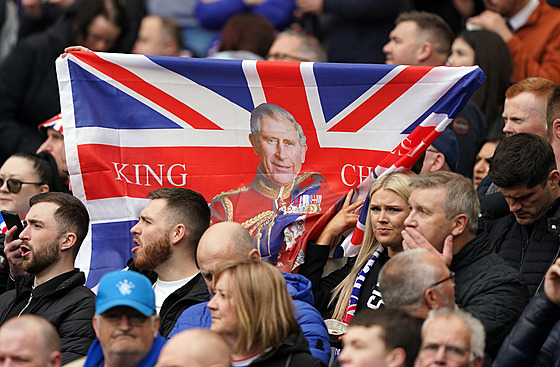 Lidé v Glasgow s britskou vlajkou a podobiznou krále Karla III. (30. dubna 2023)