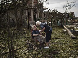 Elena Holovková sedí mezi troskami svého domu v Drukivce na východ Ukrajiny....