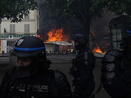 Policisté stojí u hoící budovy bhem demonstrace. Po celé Francii pochodovaly...