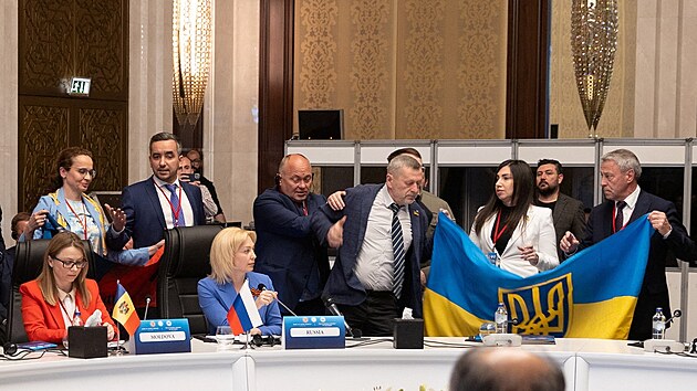 lenov ukrajinsk delegace rozvjej svou sttn vlajku vedle Olgy Timofejevov, zstupkyn vedouc rusk delegace, aby naruili jej projev bhem zasedn Parlamentnho shromdn ernomosk hospodsk spoluprce (PABSEC) v tureck Ankae. (4. kvtna 2023)