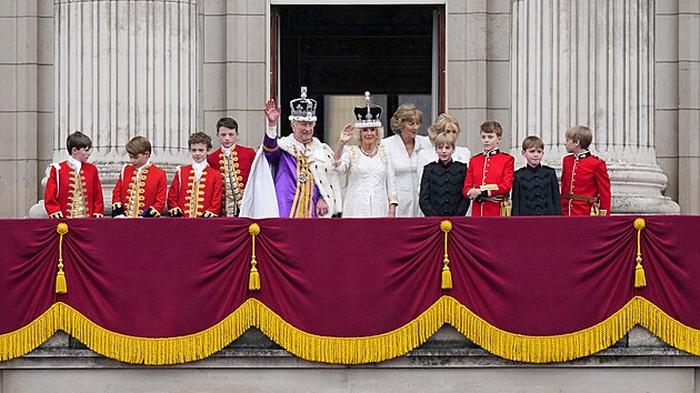 Britský král Karel III. a královna Camilla mávají davům z balkonu Buckinghamského paláce. (6. května 2023)