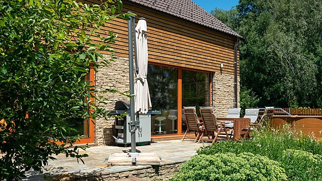 Okol� domu vyladila zahradn� architektka z jind�ichohradeck�ho ateli�ru Za M�k, kter� tak� poradila majitel�m, aby byl fas�dn� kamenn� obklad dole jako uzemn�n� a d�evo s vysoce trvanlivou �pravou ThermoWood jako leh�� prvek naho�e.