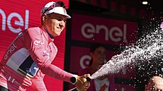 Remco Evenepoel slaví na pódiu v r��ovém trikotu vít�zství v úvodní �asovce na...