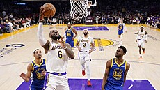 LeBron James (uprostřed) z LA Lakers zakončuje v zápase play off proti Golden...
