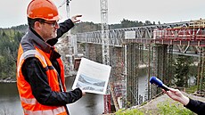 Petr ákovec ze Správy eleznic drí dokumenty z vizualizací budoucího mostu.