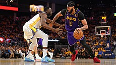 Anthony Davis (3) z Los Angeles Lakers se tlaí ke koi Golden State Warriors...