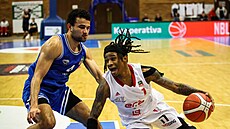 Evan Gilyard (vpravo) z Nymburka útoí v zápase s USK Praha, brání ho Patrick...