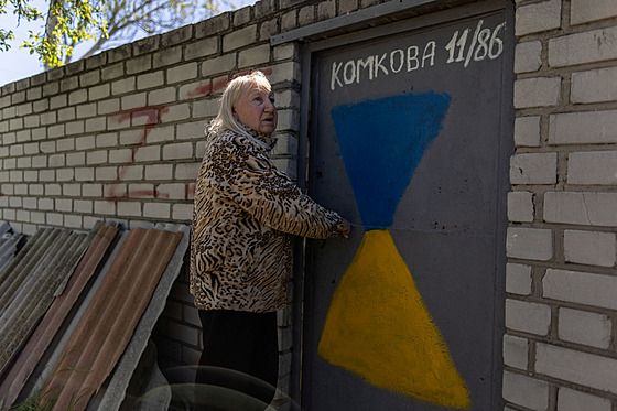 tyiasedmdesátiletá Valentyna Harasová stojí ped svým domem vedle graffiti s...
