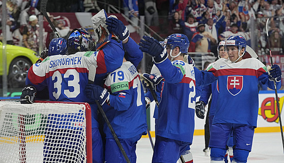 PRVNÍ VÝHRA. Sloven�tí hokejisté objímají gólmana Stanislava �korvánka po...